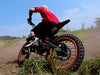A person riding an Isinwheel Monster Pro Mid-Drive Electric Dirt Bike on a dirt track, back view
